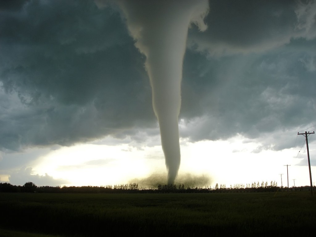 A tornado touches the ground in an open field